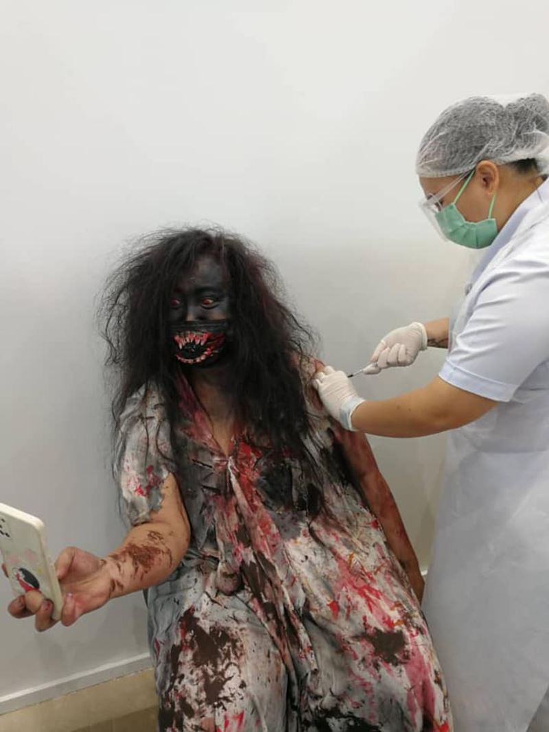malaysian dressed as “pontianak” receives covid-19 vaccine