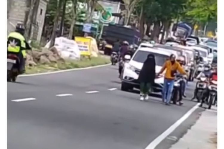 wanita tengah jalan raya punca trafik sesak teruk