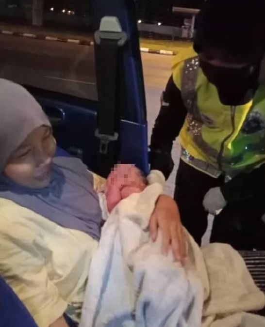 two police officers help woman to give birth safely at roadblock in kuching