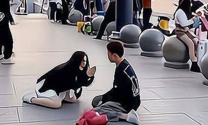 frustrated woman in china kneels in public, begs admirer to stop chasing her