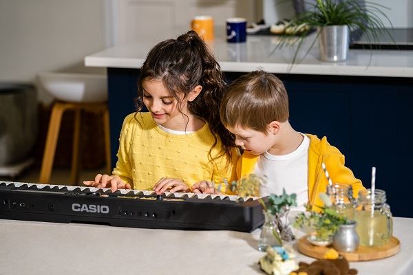 Children learning on Casio LK-S450 digital piano
