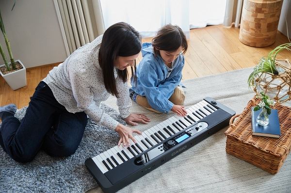 Young girl learning to play Casio piano on keyboard