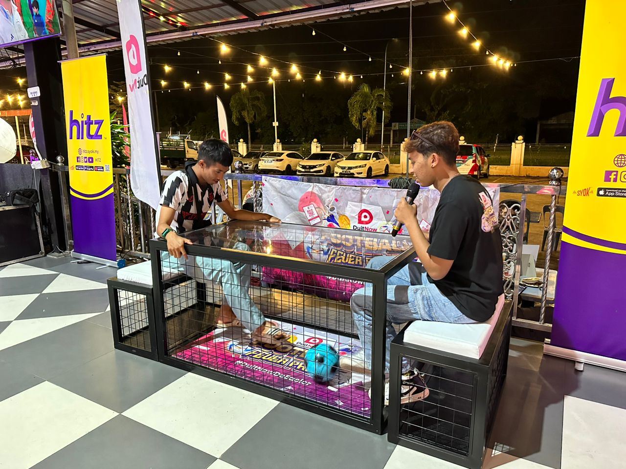 Two participants playing table football at DuitNow Football Fever Party in Perak