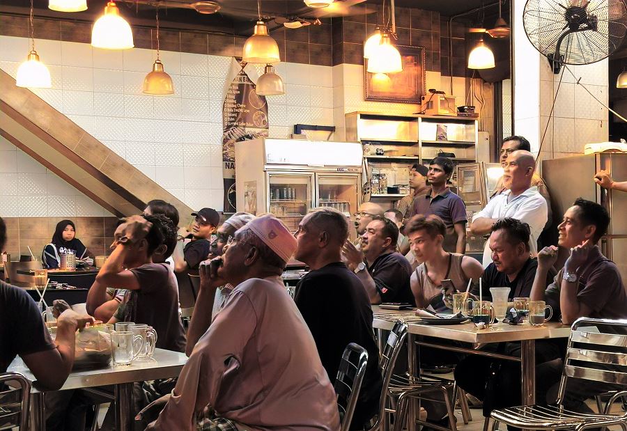 Malaysians watching football at mamak