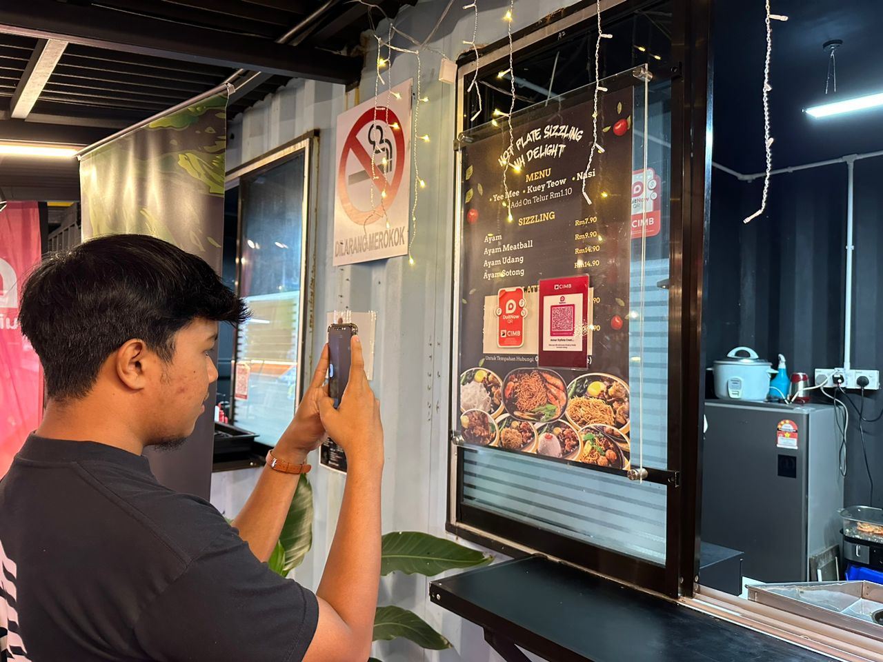 A diner scanning DuitNow QR to pay food