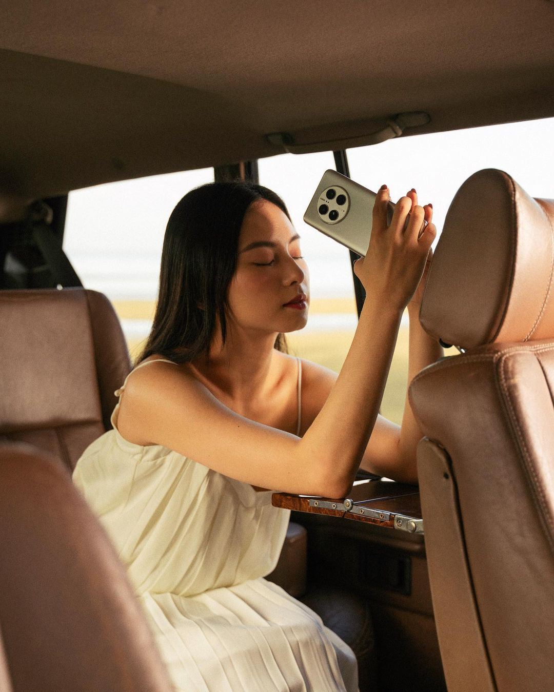 Mia sitting in car posing with HUAWEI Mate50 Pro