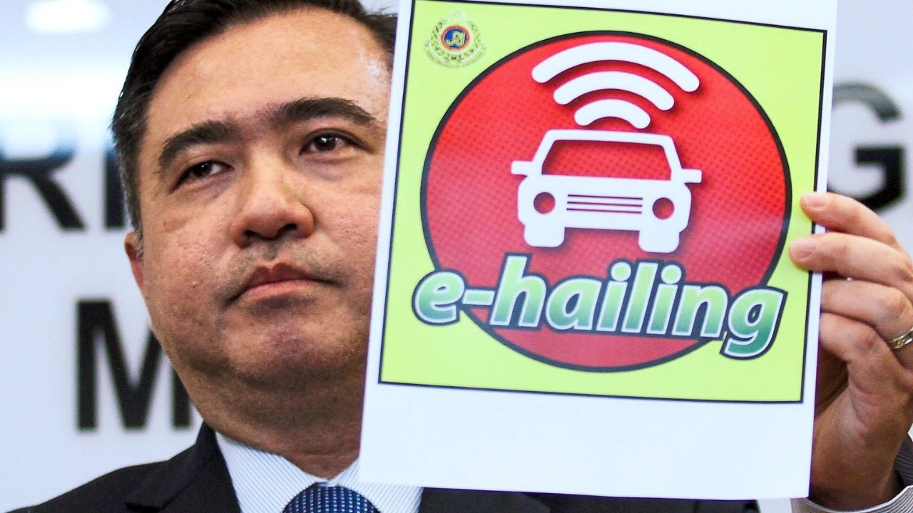 Anthony Loke holding e-Hailing sticker