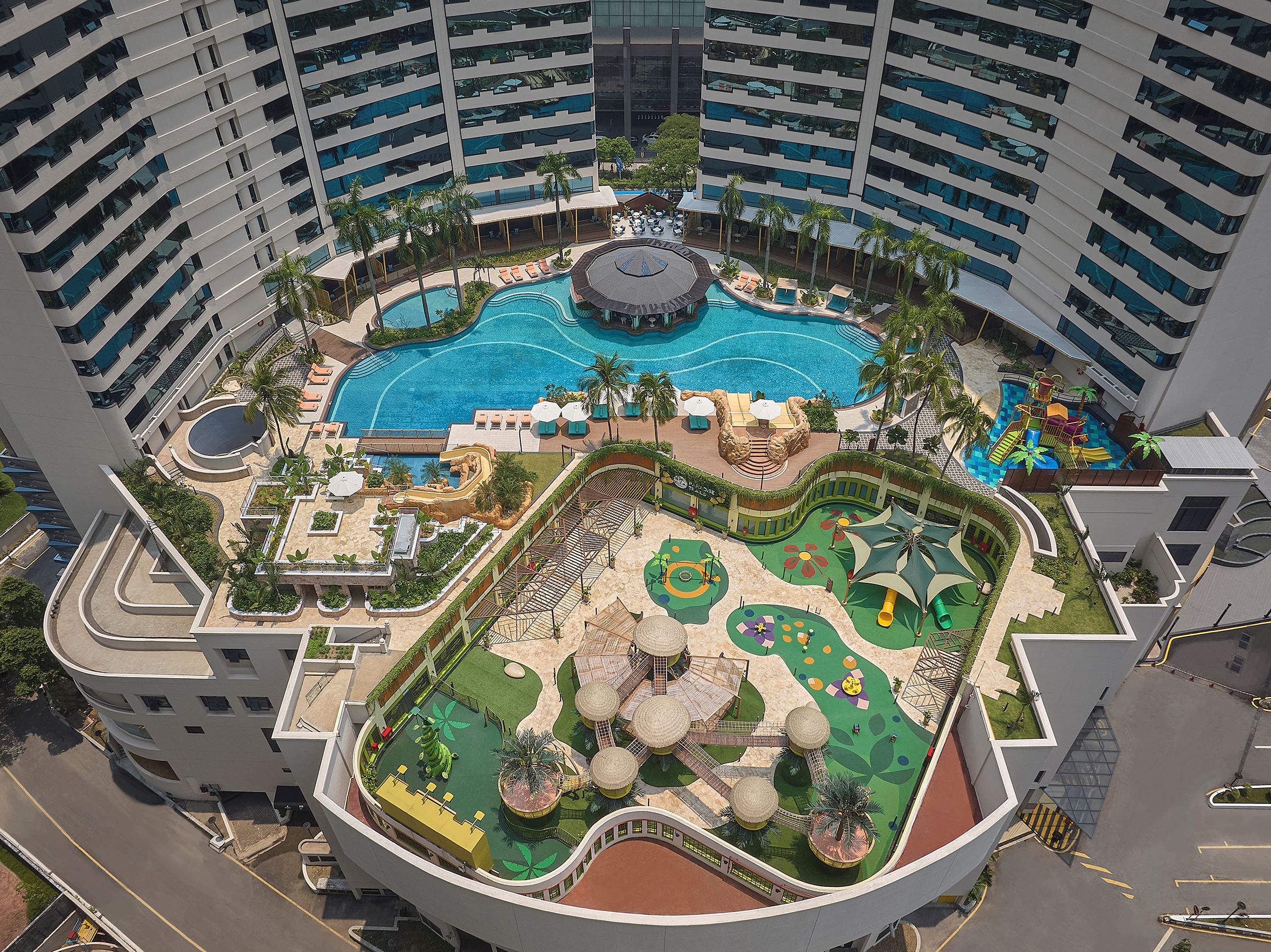 a top view of a swimming pool and park near some trees and buildings