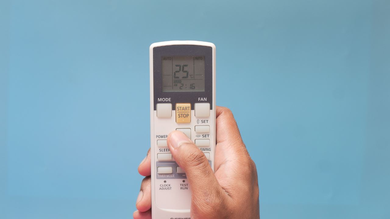 Hand holding air conditioner remote control