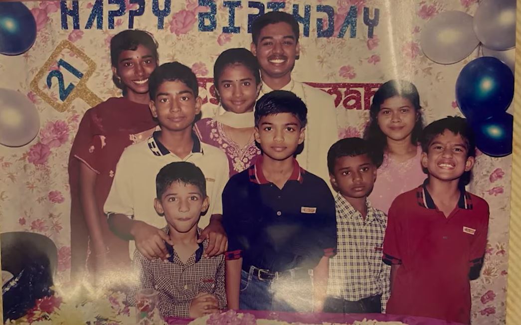 An old photo of a young Suresh and his family at a birthday party