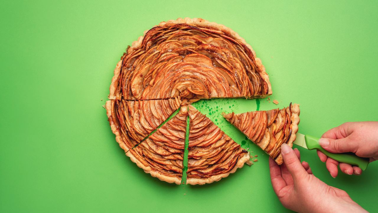 hands cutting and holding a pie