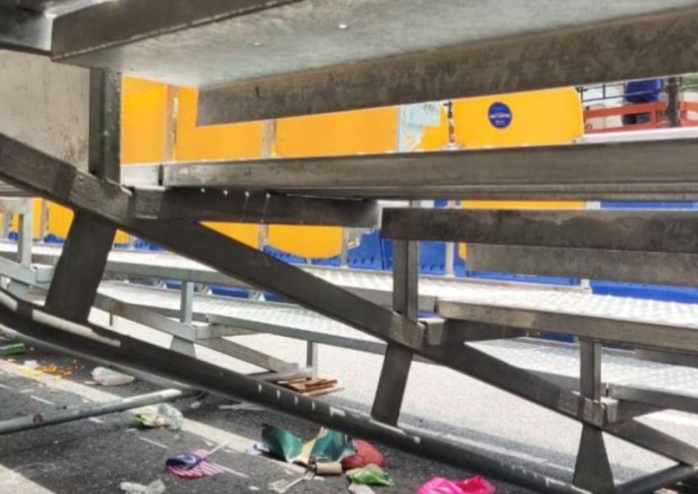 post-merdeka parade scene: grandstand littered with bottles, leftover food, and flags
