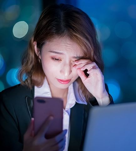 a girl holding a phone with finger rubbing eye