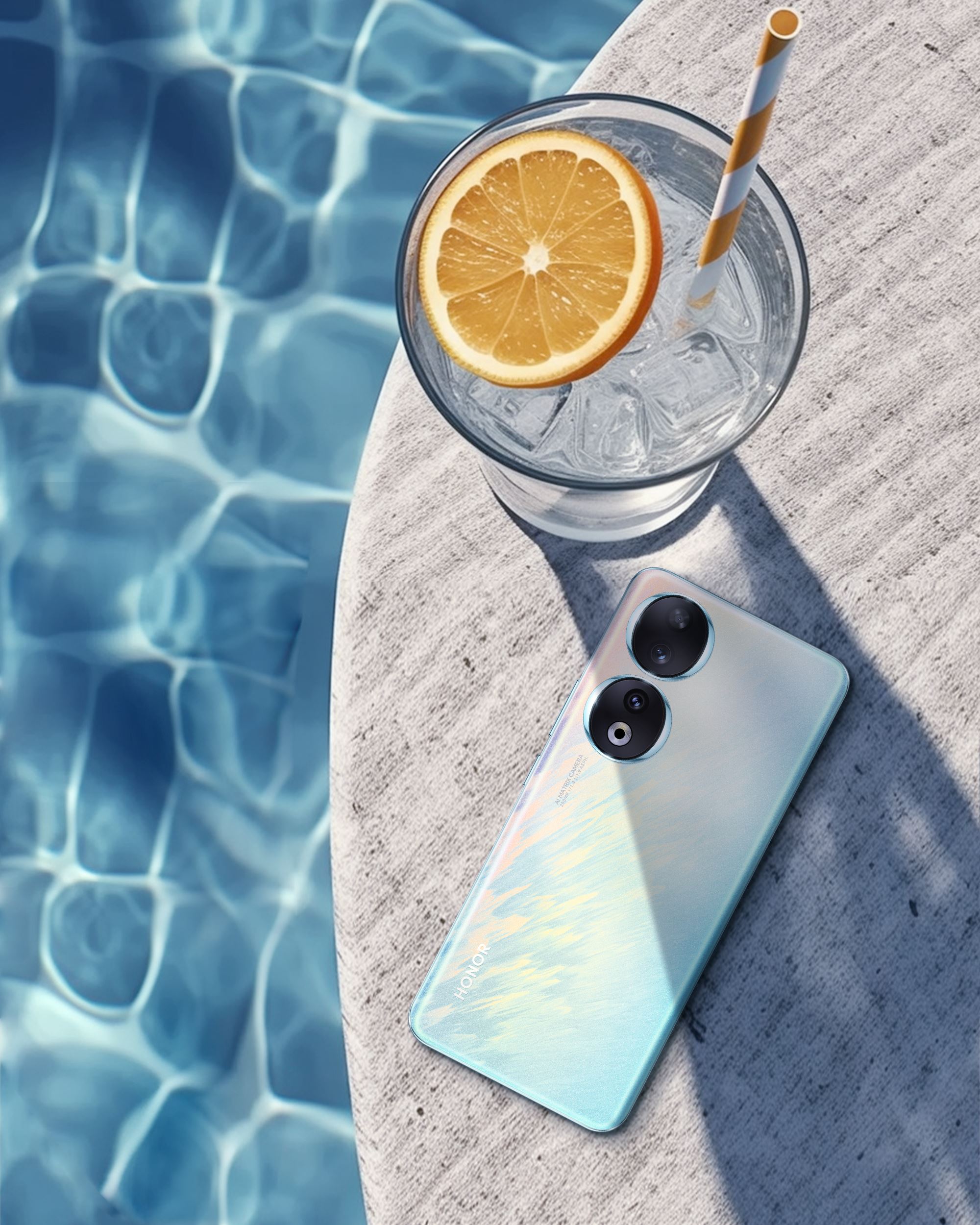 HONOR 90 phone by the pool with a drink next to it