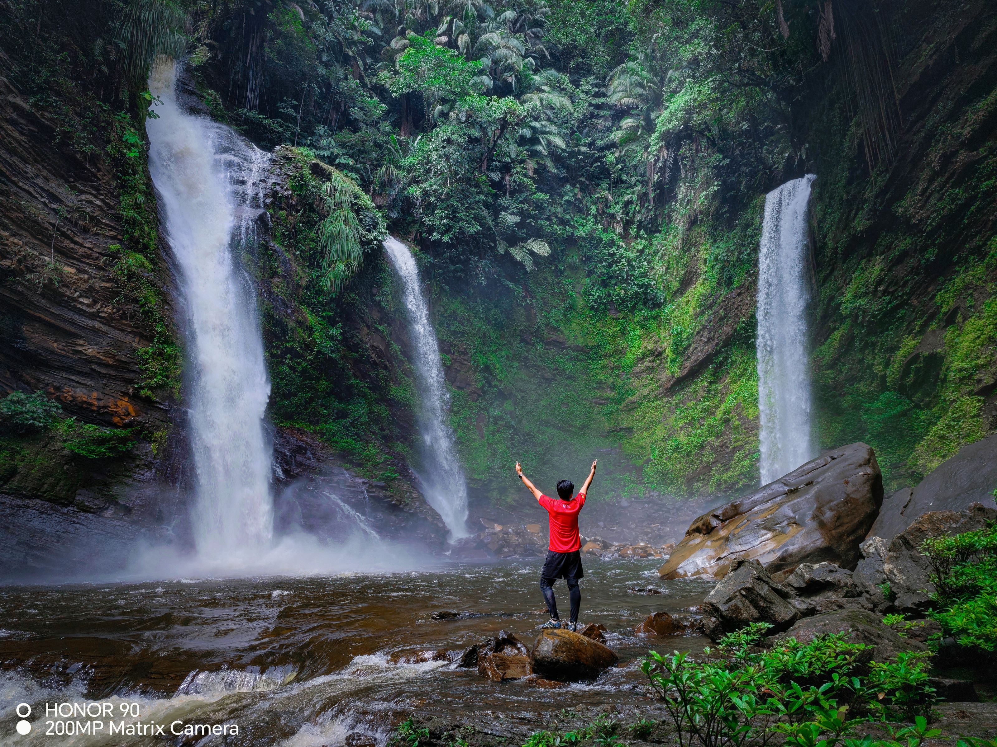 person-looking-at-waterfalls-arms-out