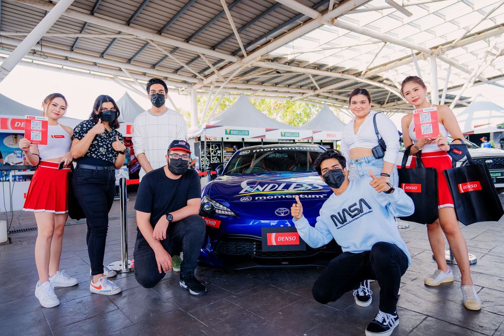 people posing for a picture with race car