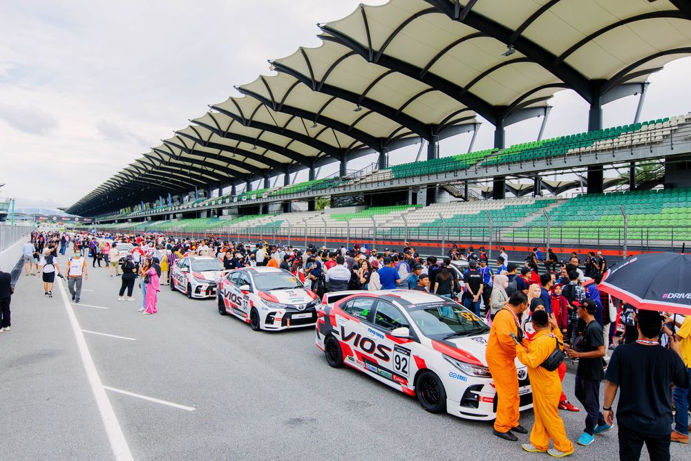 Sepang racetrack with race cars and people