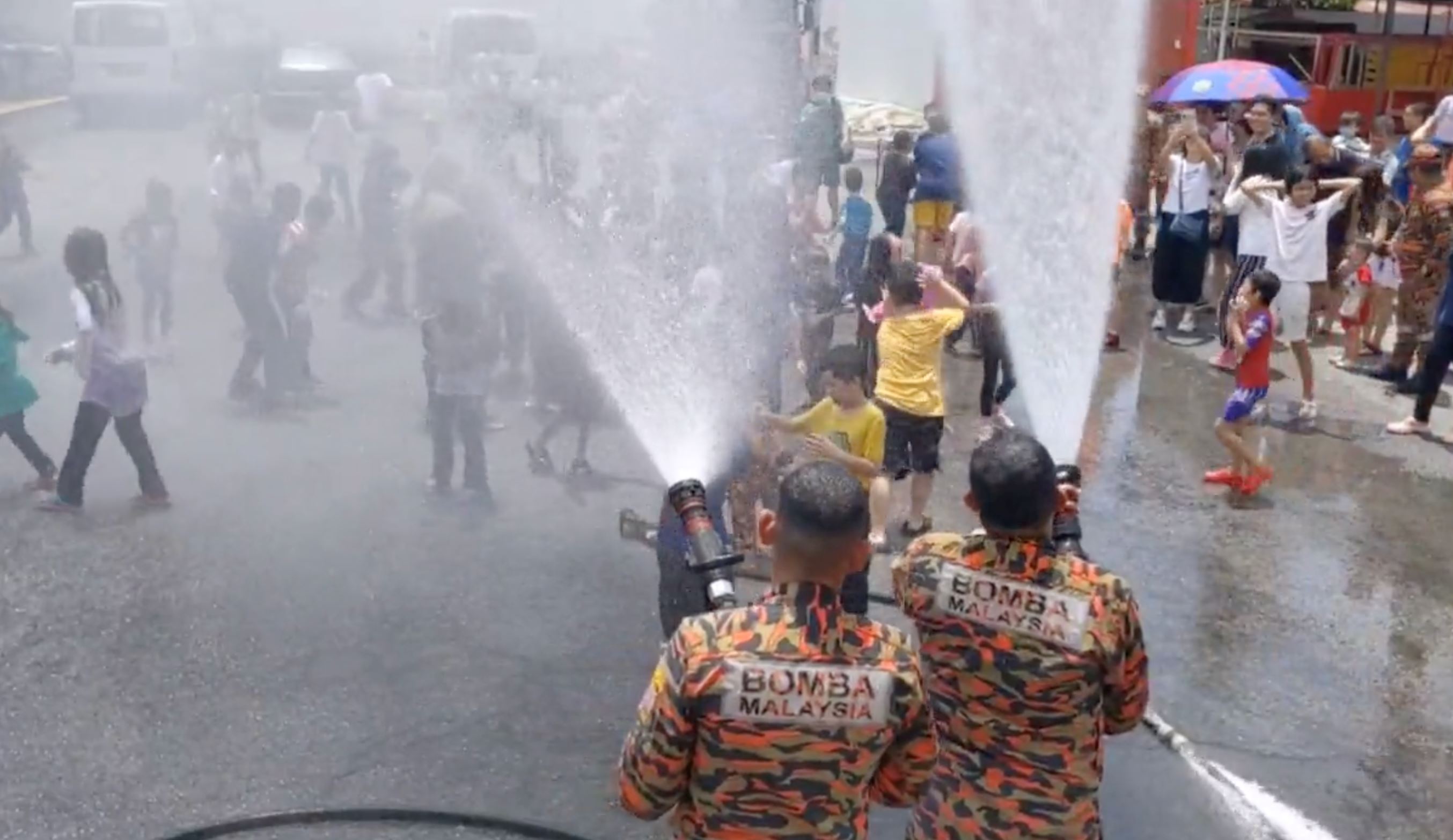 fun! kids in georgetown celebrate malaysia day with a fire hydrant shower with penang bomba!
