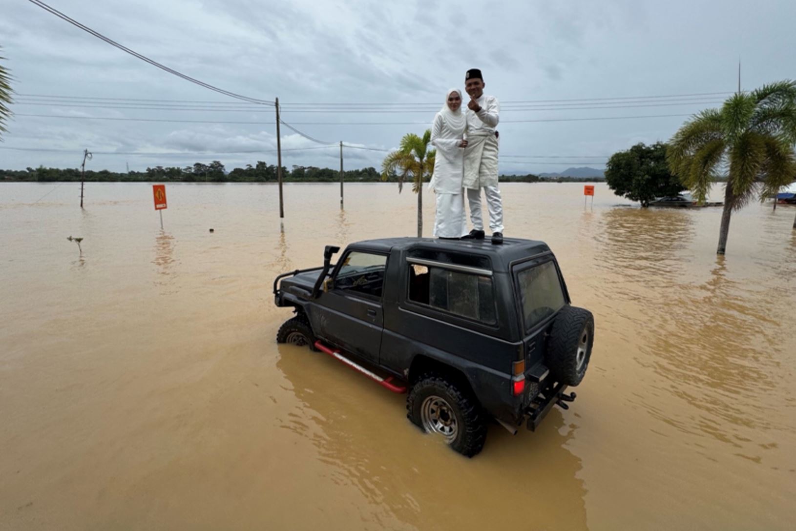 couple celebrates wedding in kedah floods with a fun photoshoot on raft and 4x4 vehicle!