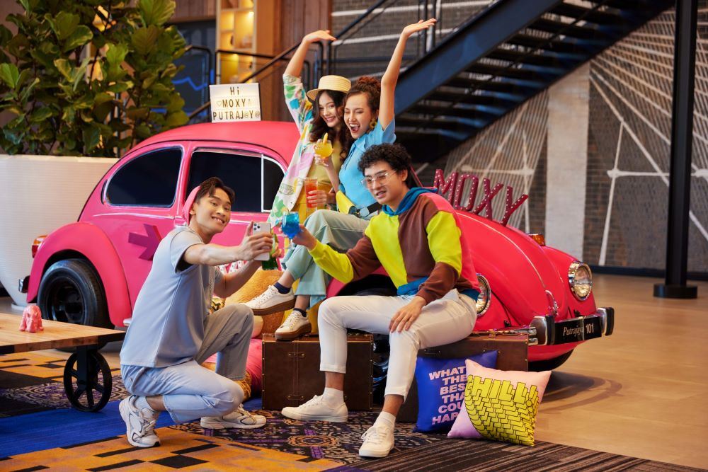 Four youths taking a selfie with eclectic decorations at Moxy Putrajaya