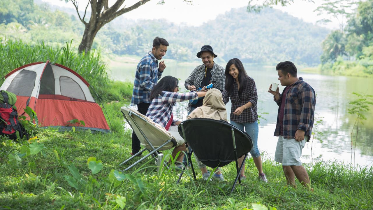 A group of friends camping by the lake