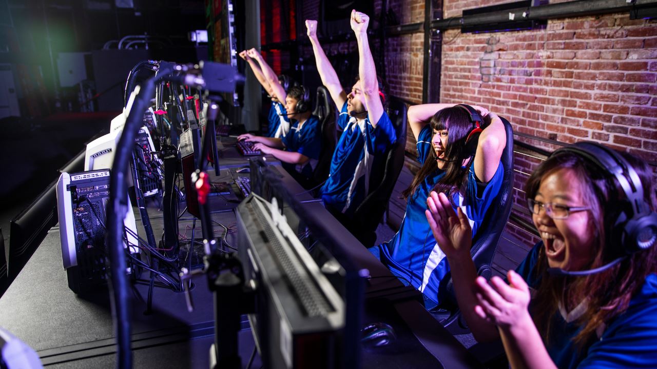 ESports gamers cheering in front of desktop computers