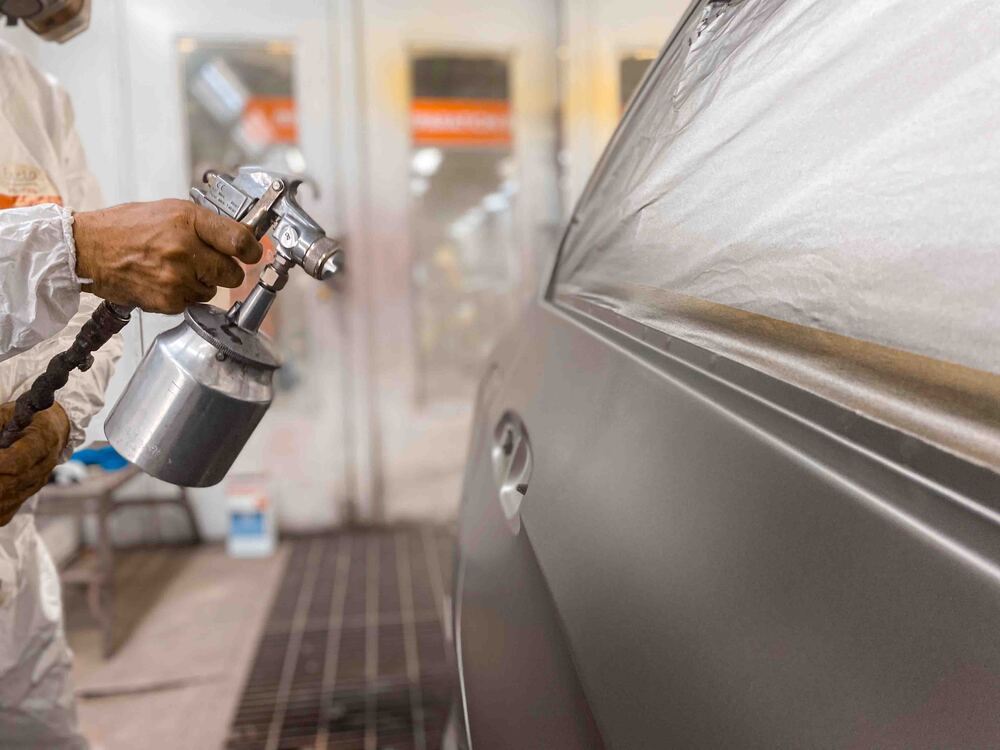 A person spray painting a car