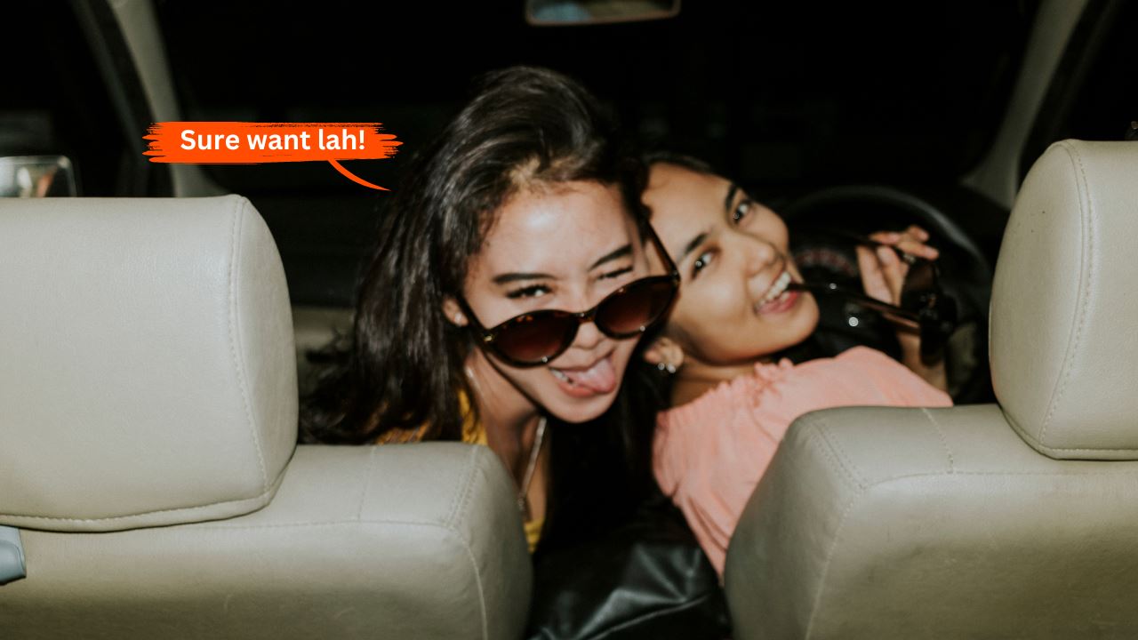 Two Asian women on the front seats of the car looking back and smiling at the camera