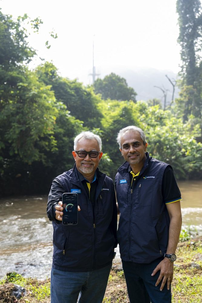 2 people posing for the camera with a phone