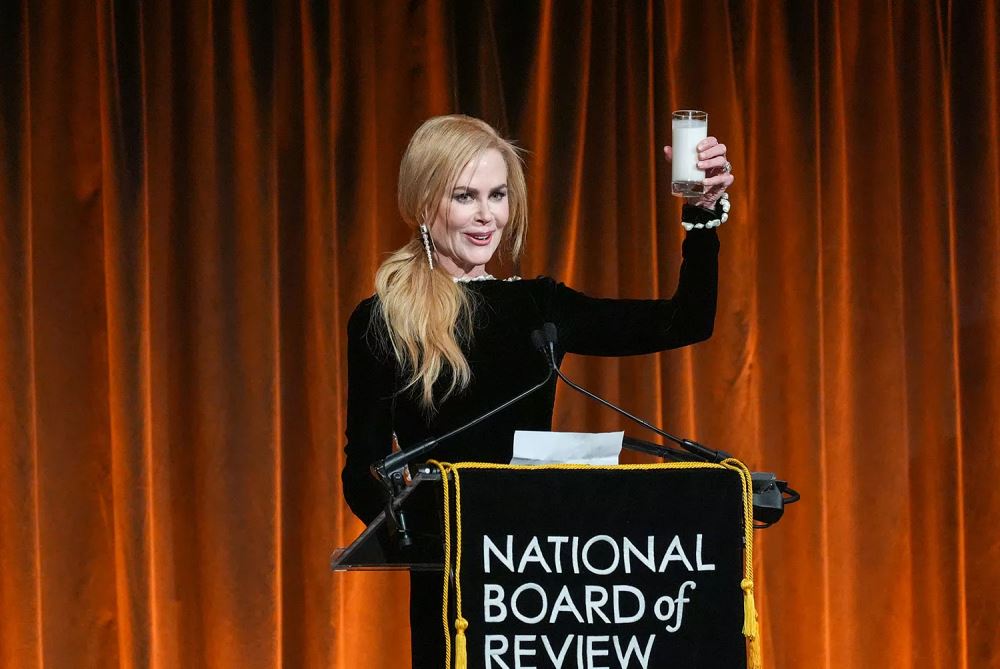 nicole kidman raises a glass of milk while accepting award