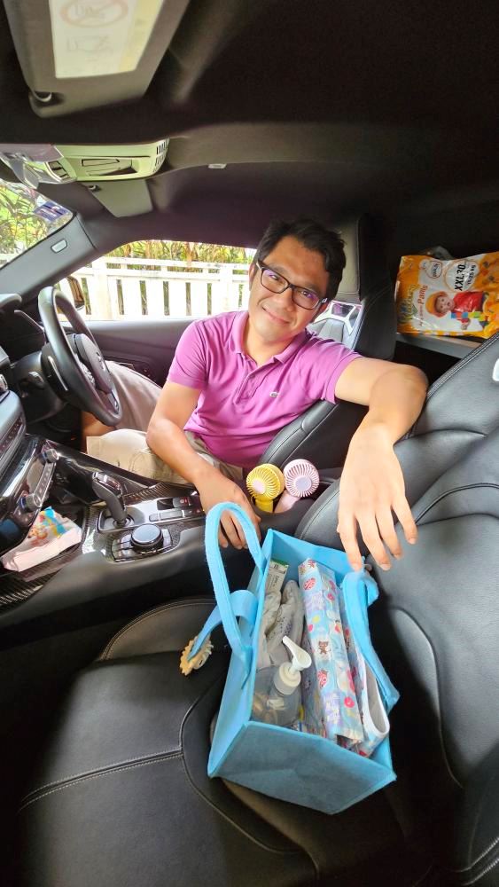 A man and baby essentials in his car