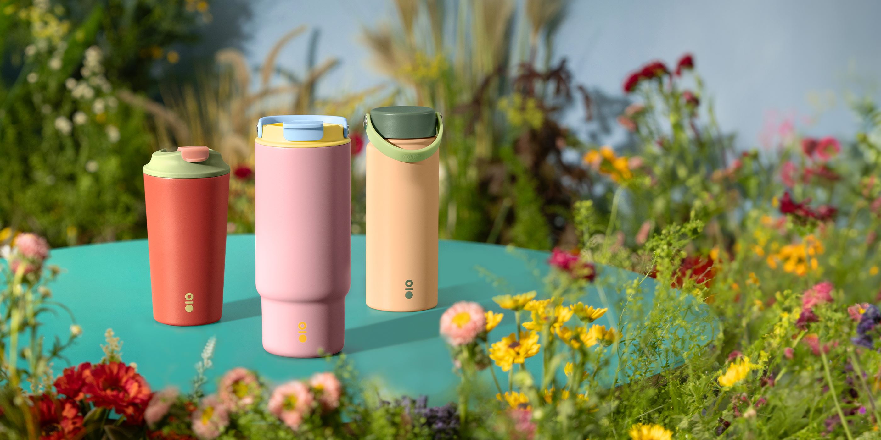Three different types of Tumblers on a table surrounded by greenery