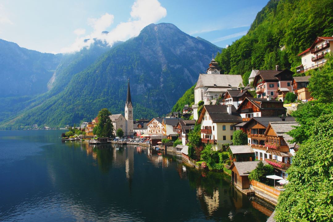 A lake with mountains in the background and houses on the side in Hallstat