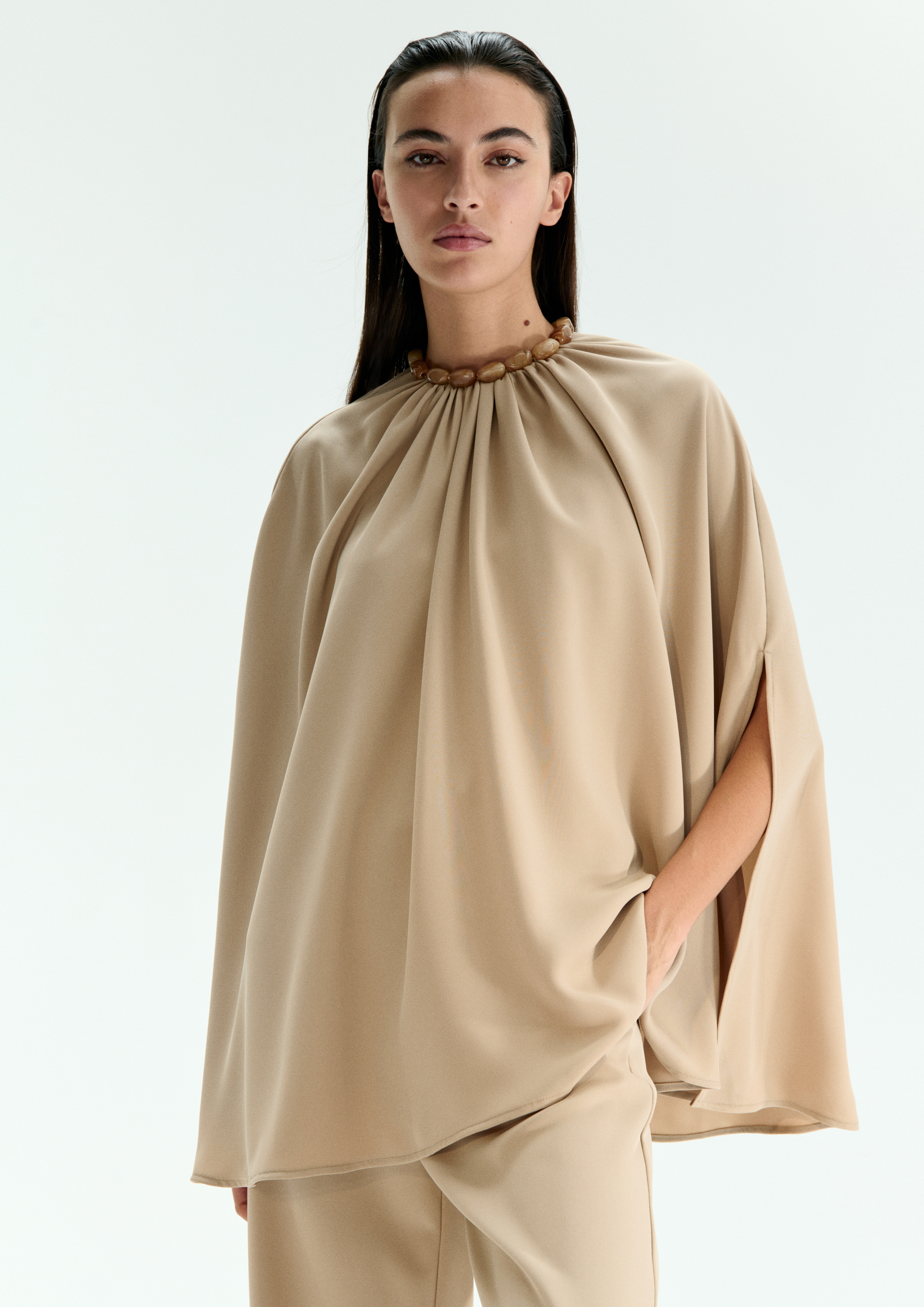 A model posing in a beige set