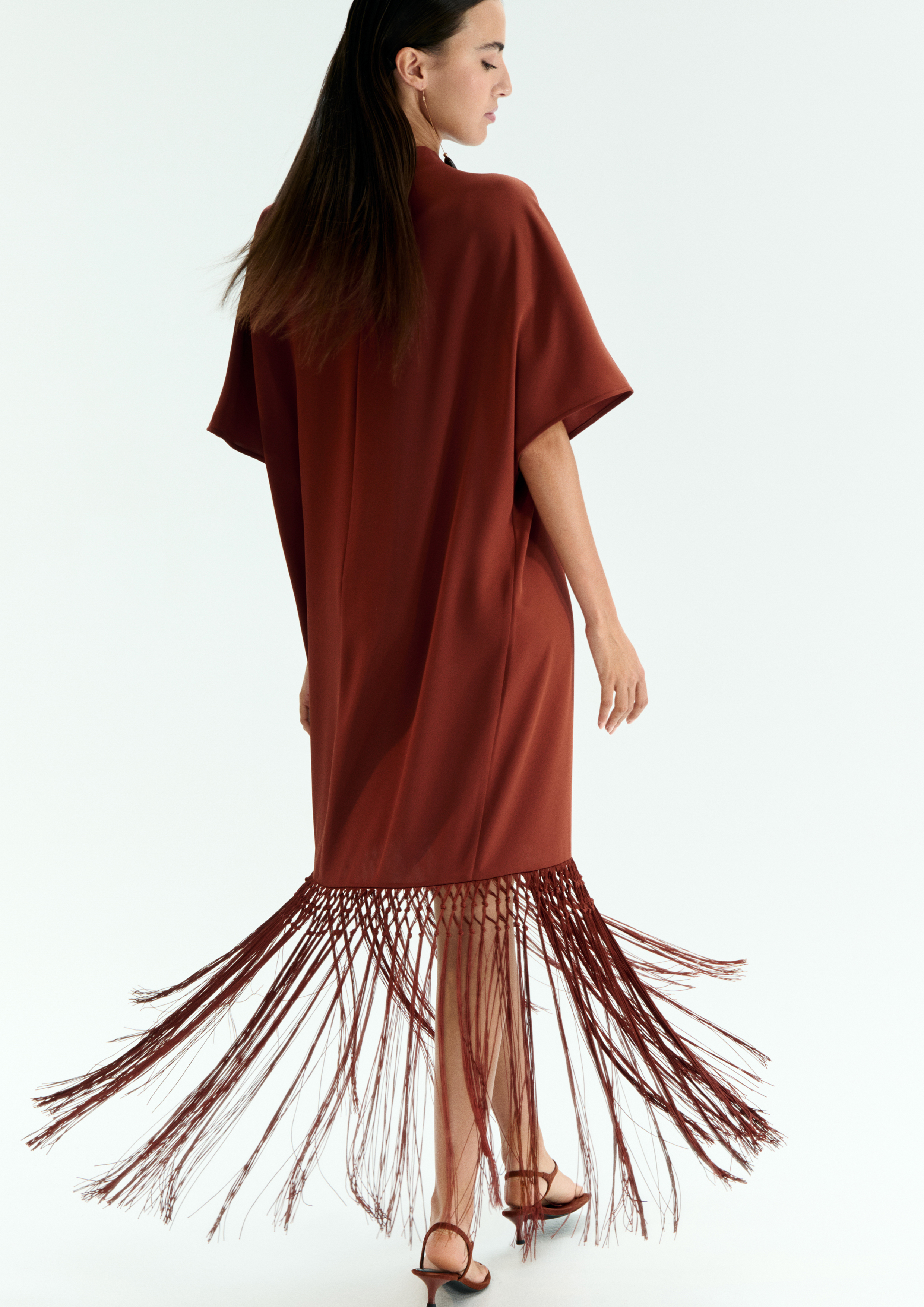 A model posing in a copper dress