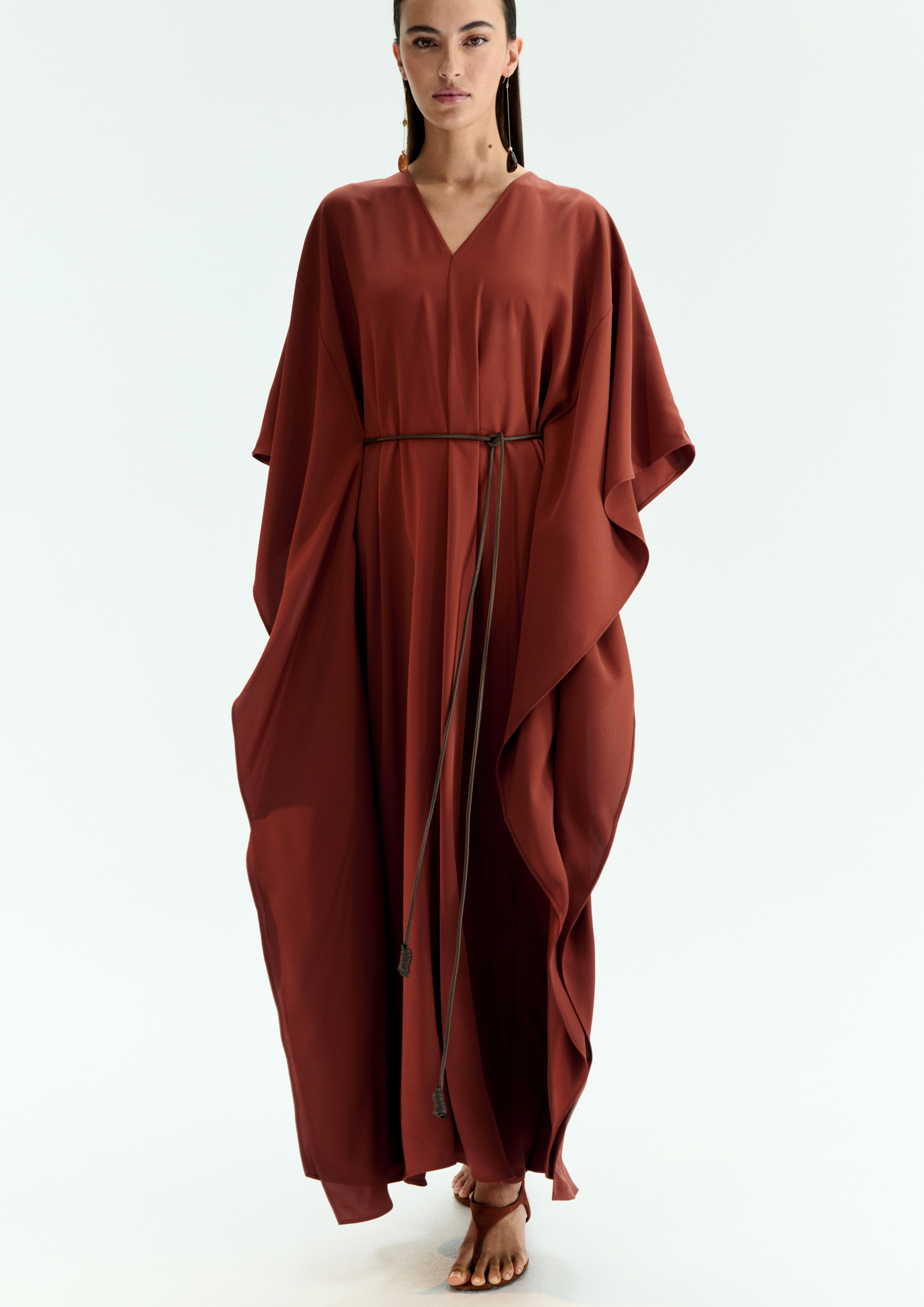 A model posing in a copper kaftan