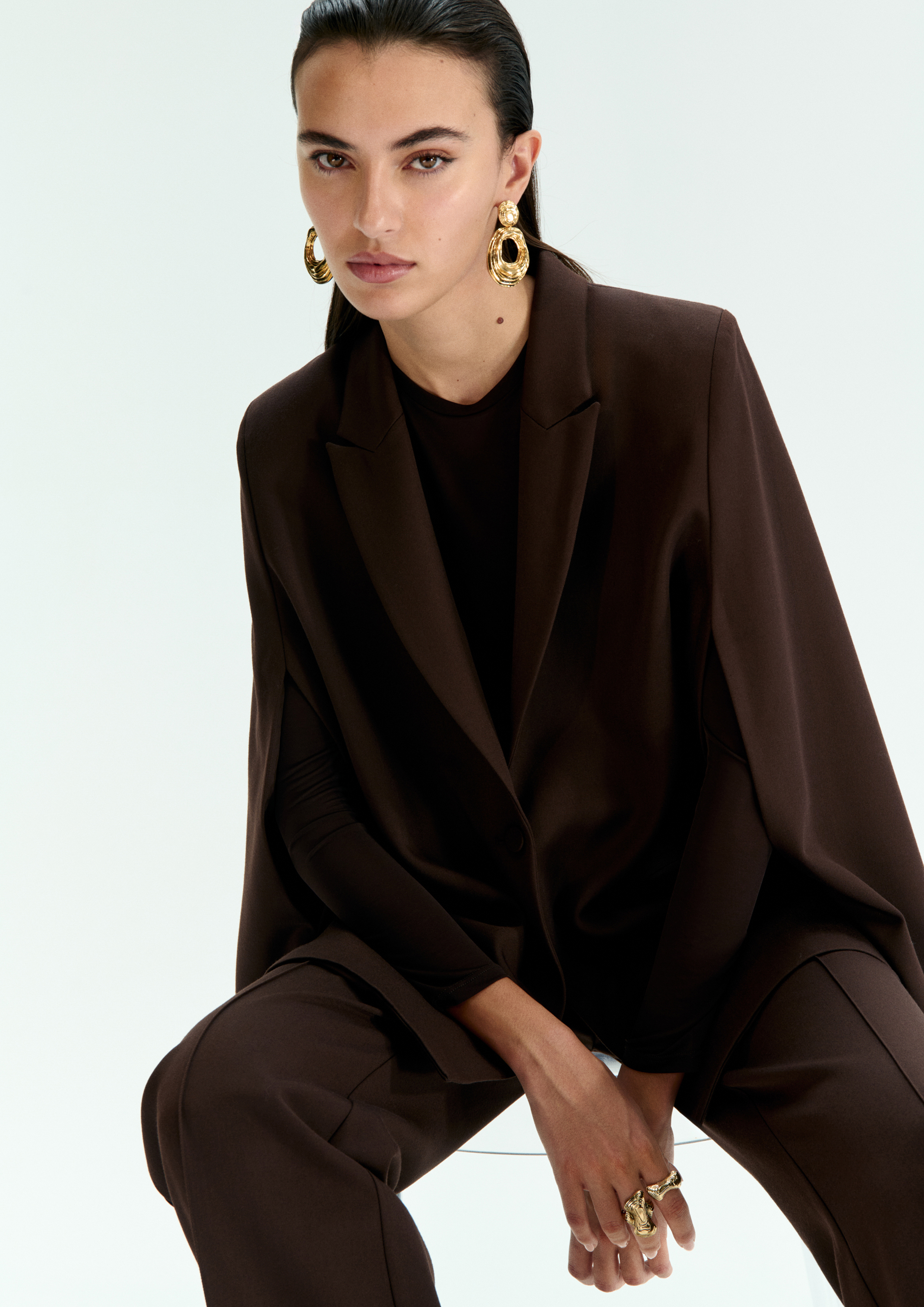 A model posing in a dark brown set