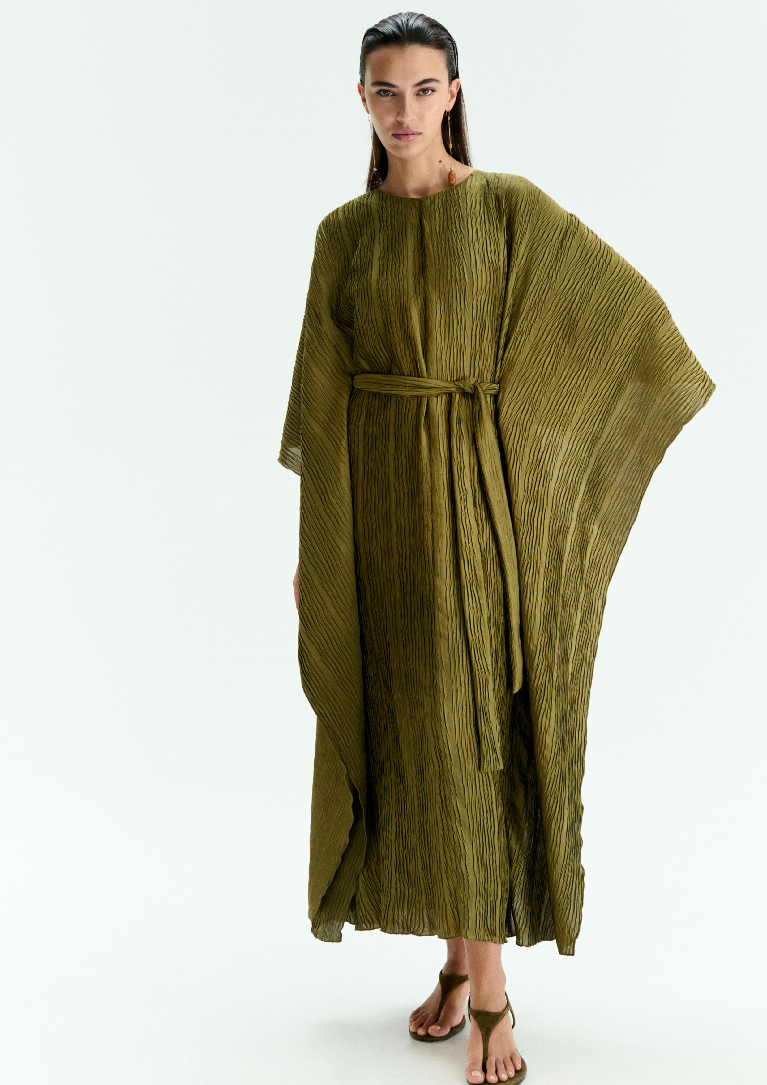 A model posing in a green batwing kaftan