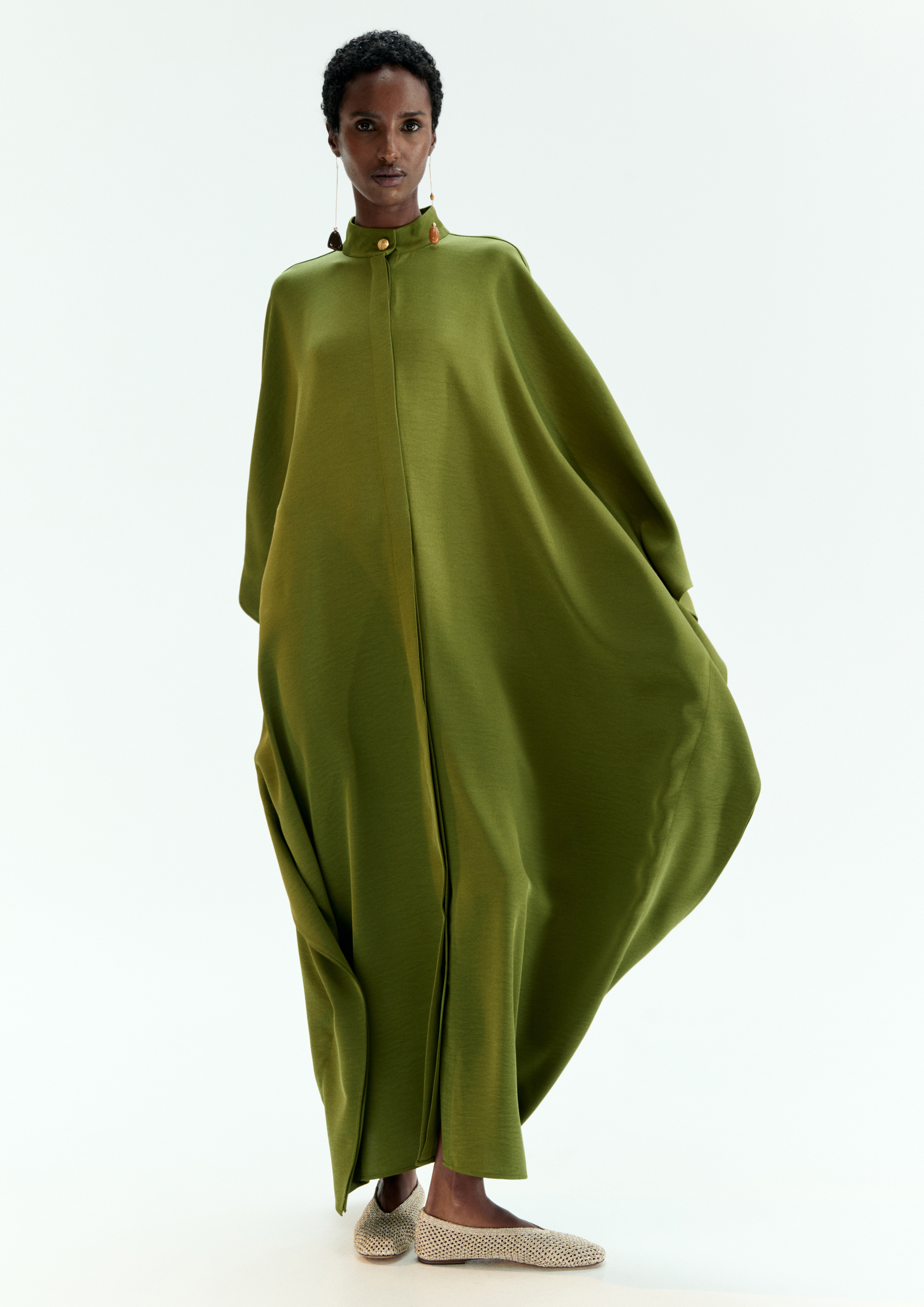 A model posing in a green kaftan