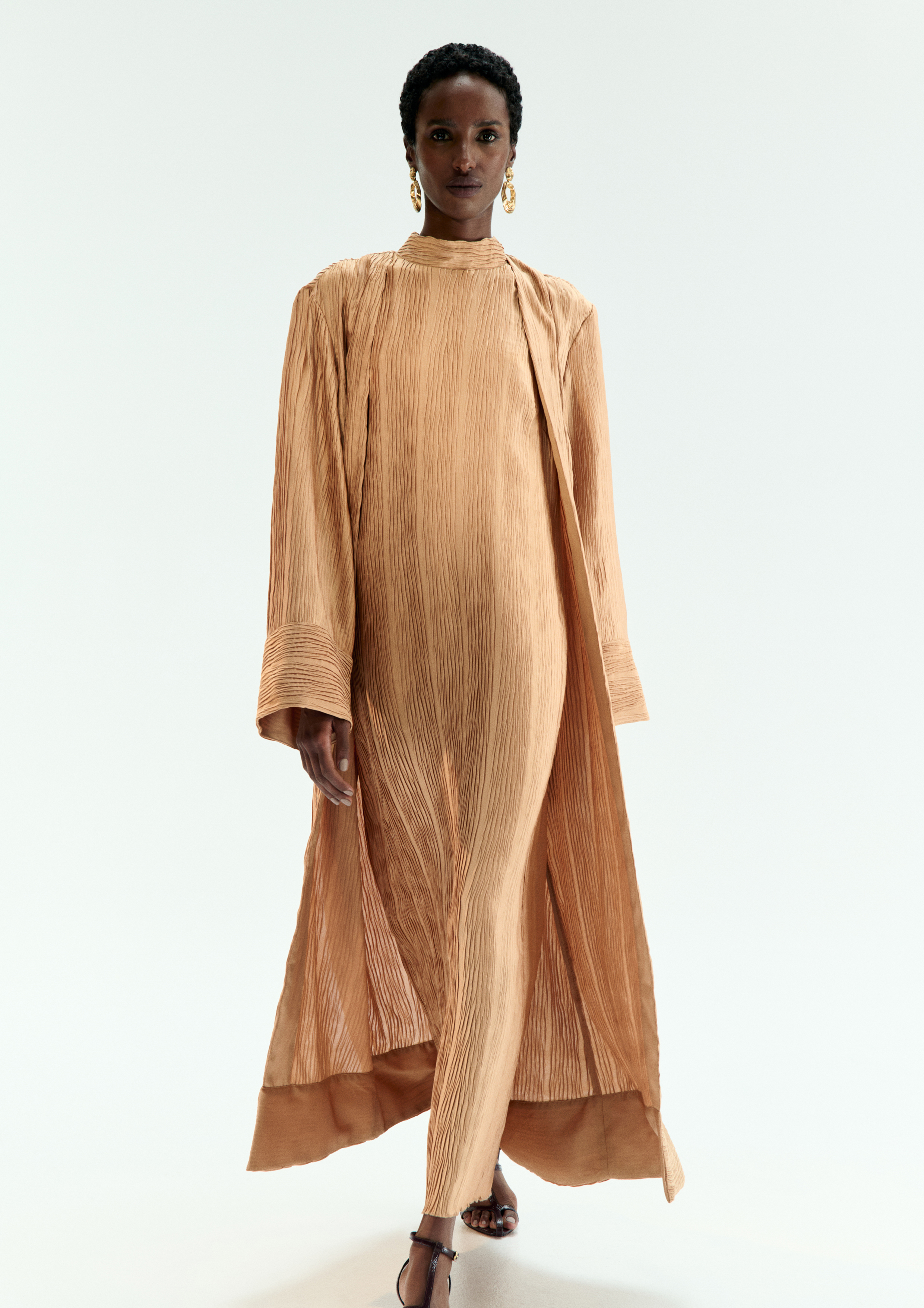 A model posing in a light brown set