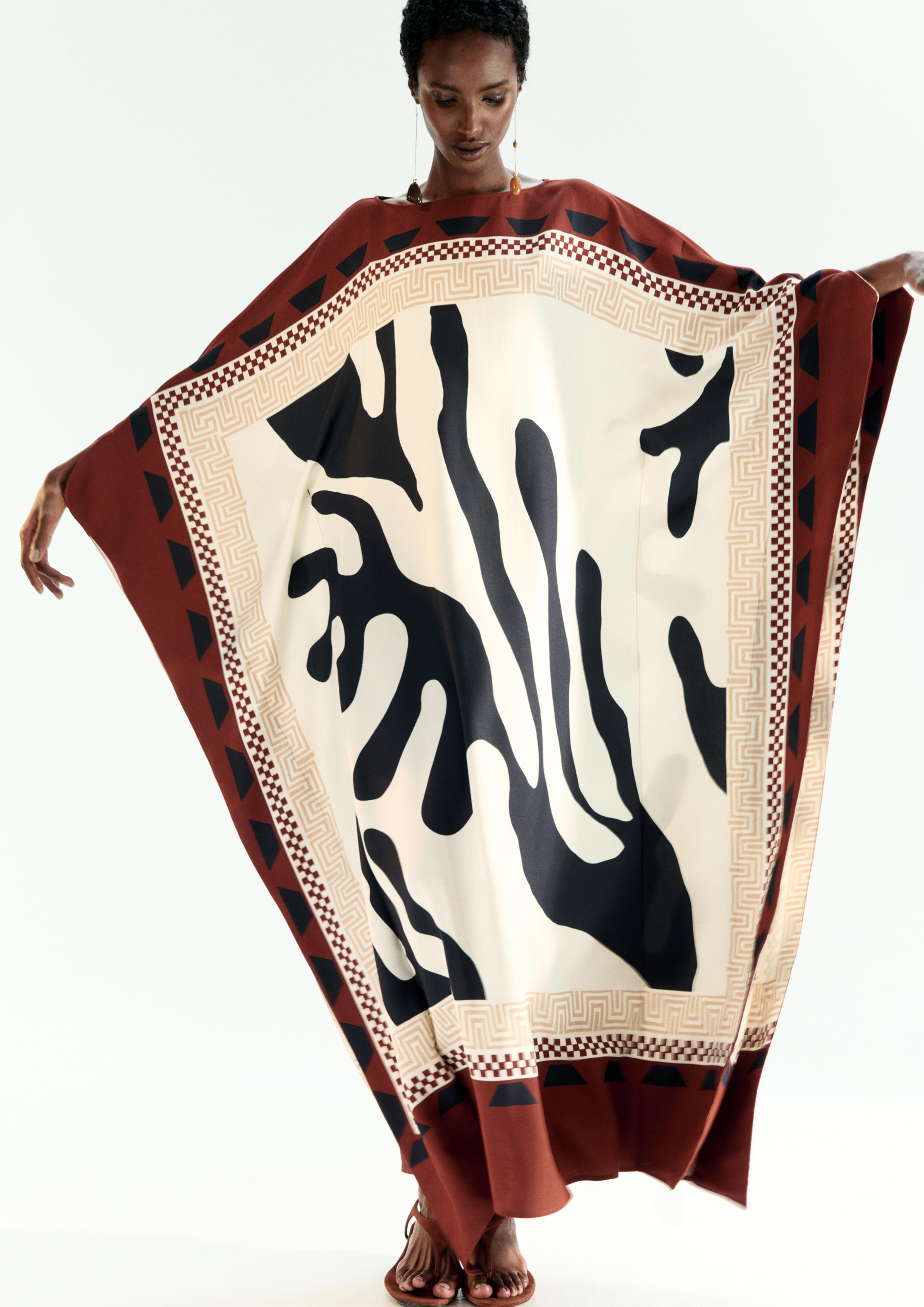 A model posing in a multi-printed kaftan