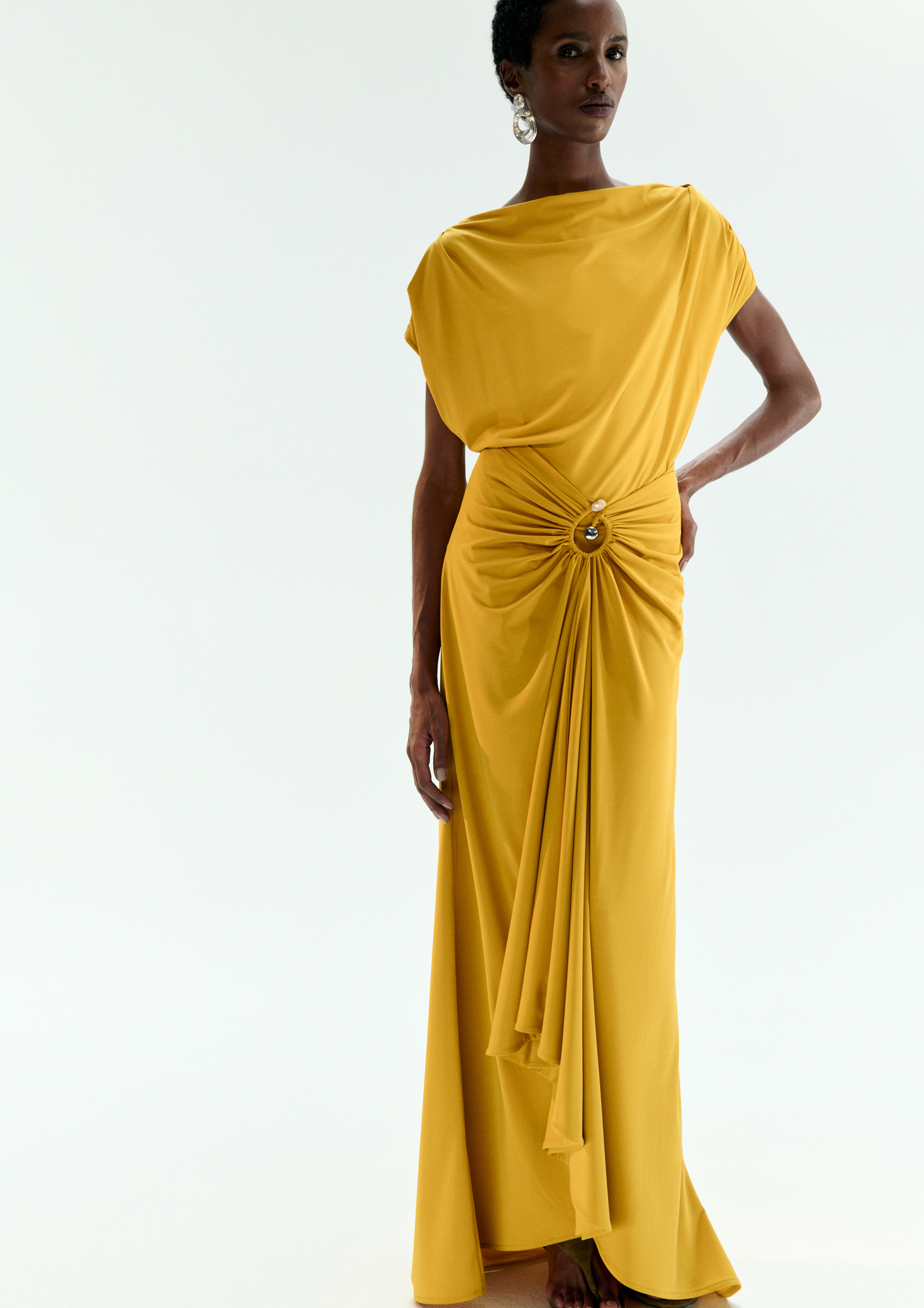 A model posing in a mustard dress