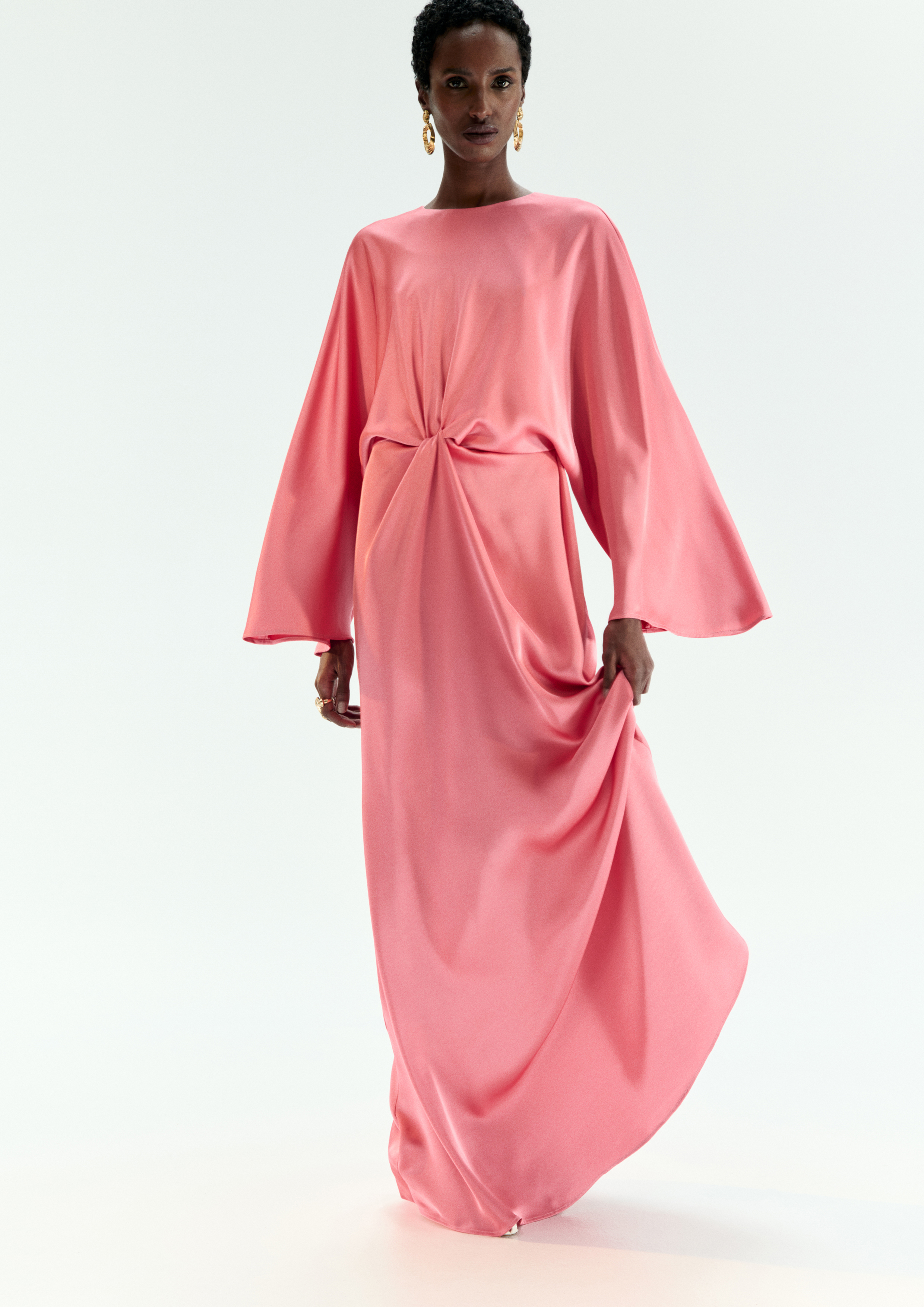 A model posing in a pink kaftan