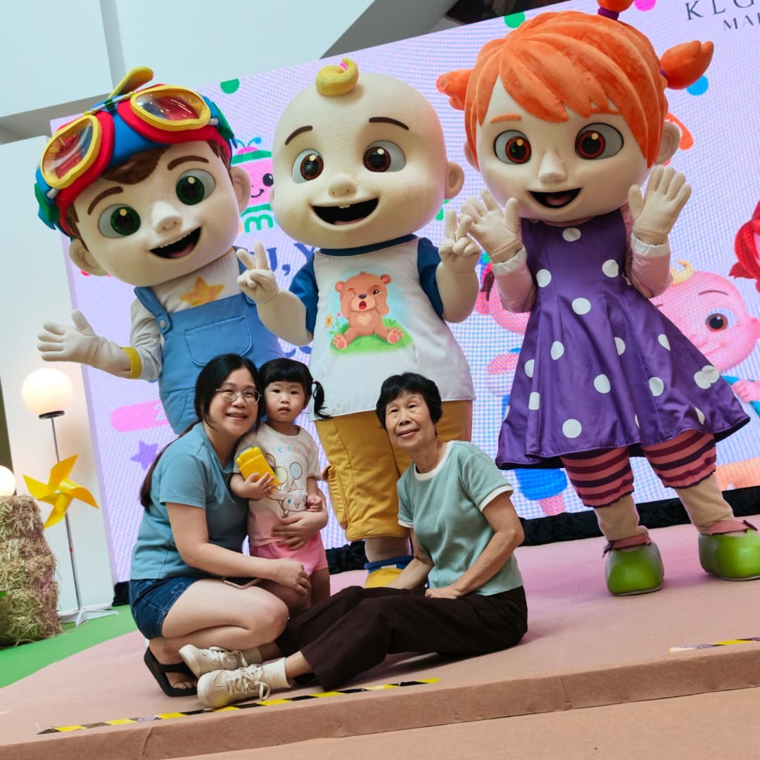 family taking picture with cocomelon