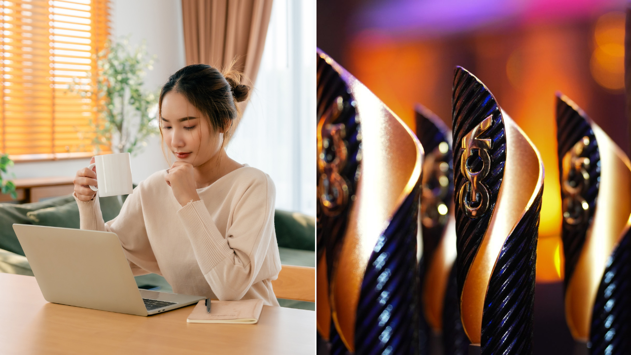 A girl looking at her laptop while having a drink and some trophies lined up