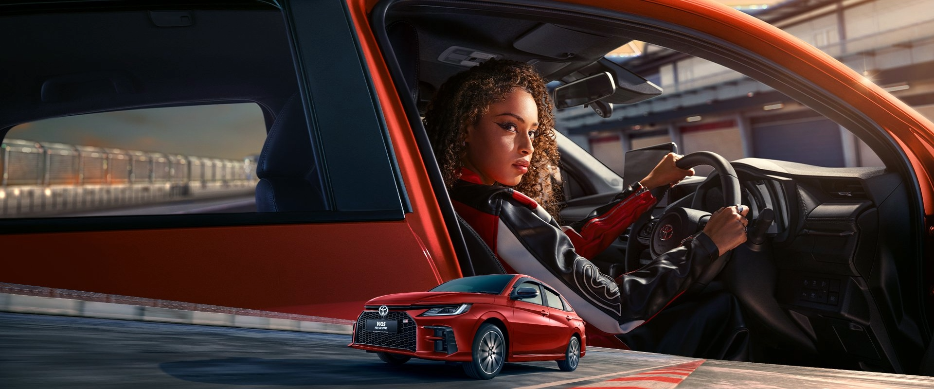 Woman on the driver’s seat of a red Toyota Vios HEV GR Sport