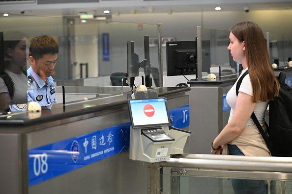 一名外国旅客正在中国某机场的出入境检查柜枱接受入境审查。